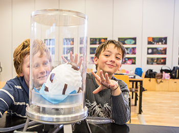 Zwei Schüler im DESY-Vakuumlabor experimentieren mit einem Schokokuss